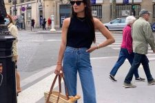 15 a classic spring to summer outfit with a black sleeveless top, blue flare jeans, black slides and a straw hat is easy and simple