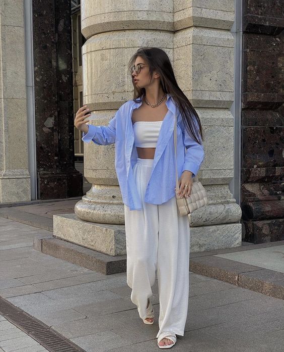 a cool casual outfit with a bra top, high waisted pants, creamy slides, a grey bag and an oversized blue shirt