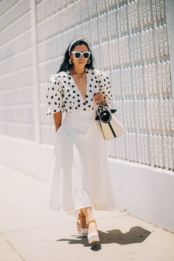a white polka dot shirt, a white linen A line midi skirt, espadrilles and a two tone bag plus layered necklaces
