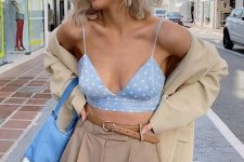 18 beige high-waisted trousers, a blue polka dot bra top, a neutral blazer and a blue bag for an office look