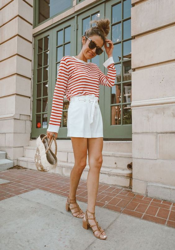 a red and white striped long sleeve top, white high waisted shorts, brown gladiator shoes and a straw bag