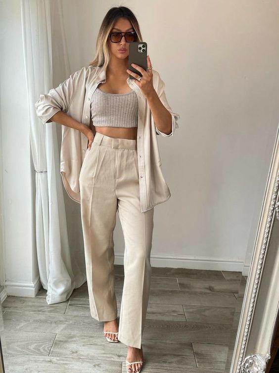 a neutral coordinating set - an oversized shirt and high waisted pants, a grey crop top and minimalist shoes for a brunch