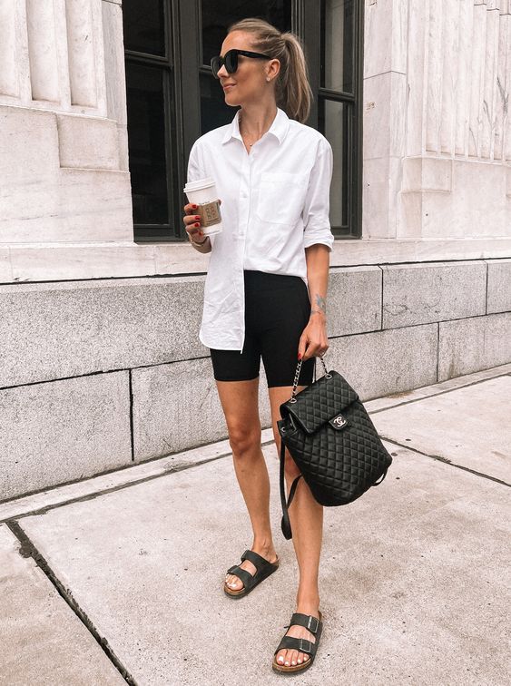 a simple monochromatic look with a white shirt, black biker shorts, black birkenstocks, a black backpack is ideal for summer