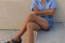 23 a simple summer outfit with a blue oversized shirt, blue denim shorts, black slides and layered necklaces and neutral bag