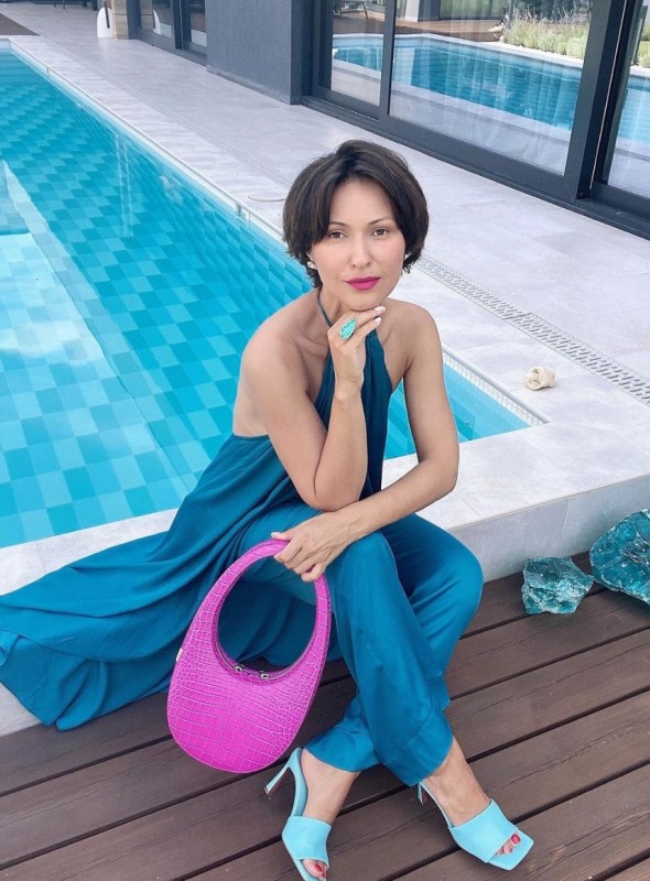 a refined summer brunch look with a teal halter neckline long top and pants, blue heels and a fuchsia mini bag