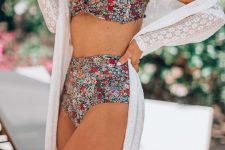 27 a romantic look with a bold floral print bikini with a tied and draped top and a high waisted bottom, a white lace cover up