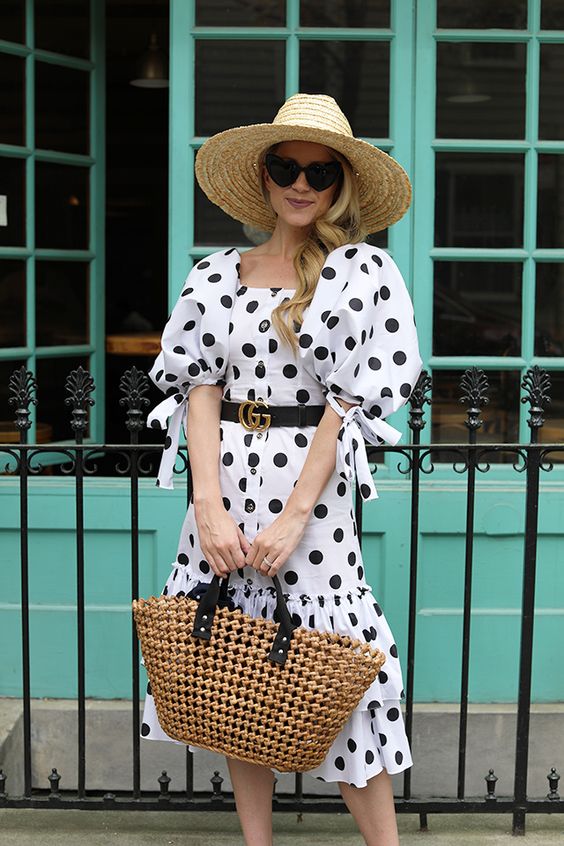 a white polka dot midi dress, a black belt, a woven bag and a straw hat are a cool and pretty solution for summer