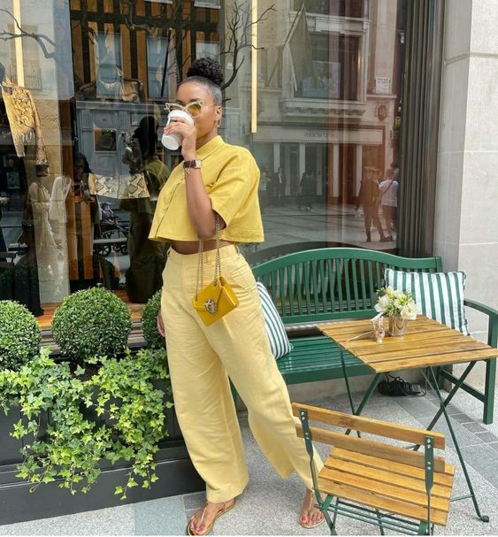a total yellow brunch outfit with a linen cropped shirt, linen pants, gold sandals and a tiny yellow bag