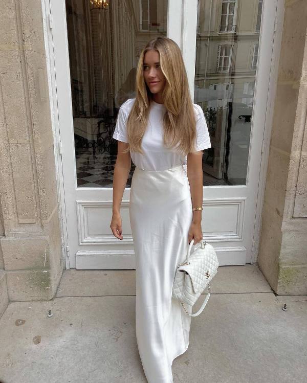 a white t shirt, a creamy slip maxi skirt and a white bag are a very simple look done in all neutral shades