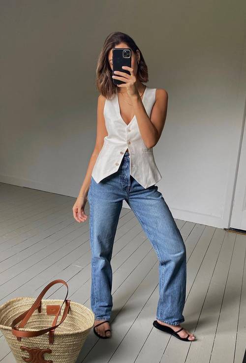a white waistcoat, blue high waisted jeans, black minimalsit sandals and a basket bag are a lovely look with a casual feel