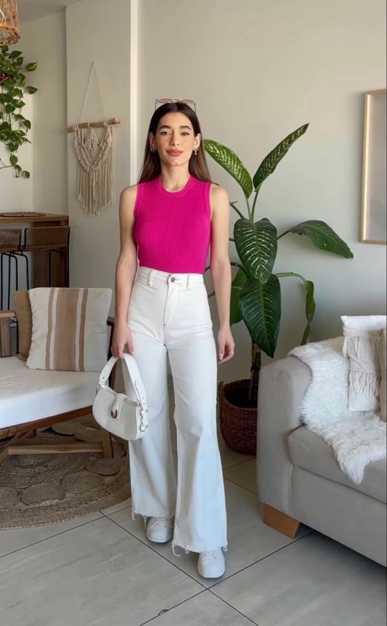 a simple summer work look with a fuchsia sleeveless top, white high waisted flare jeans, white sneakers and a white bag