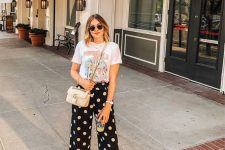 35 a casual summer look with a printed t-shirt, black polka dot pants, black slippers, a pink bag