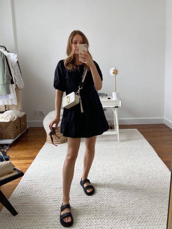 a black cotton A line dress, black birkenstocks and a white bag with a gold logo are a chic combo for every day