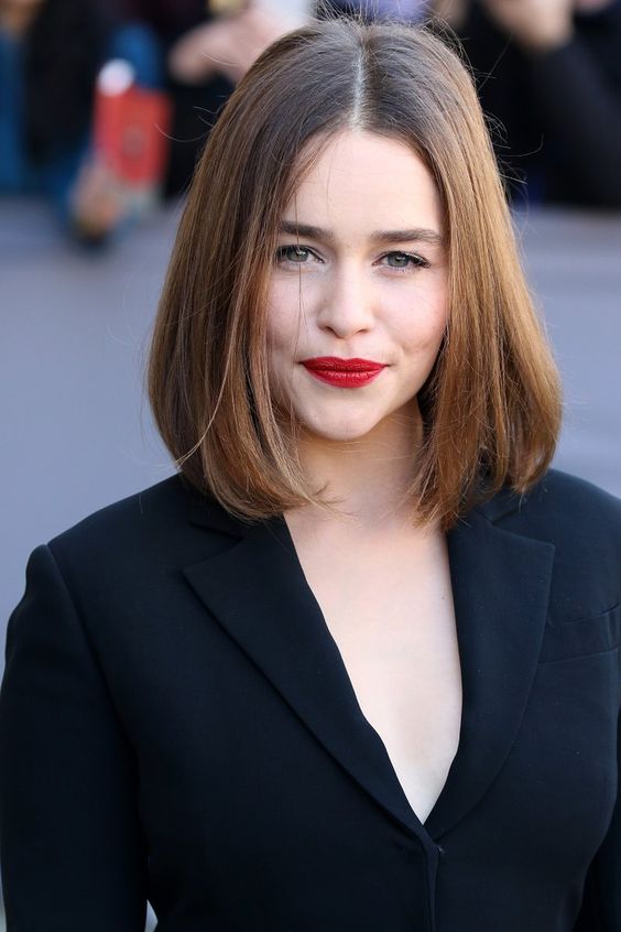 Emilia Clarke wearing a dark brunette clavicut with a touch of balayage and side parting is timeless classics