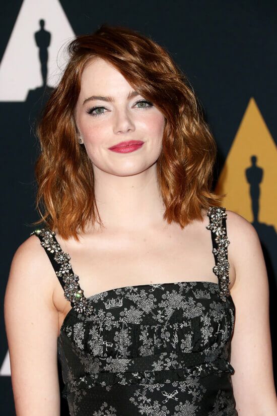 Emma Stone rocking red messy waves done in a clavicut looks bright and all cool