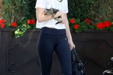 Gigi Hadid wearing black leggings and trainers, a grey bra top and a white t-shirt looks awesome