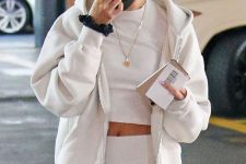 Hailey Baldwin wearing a neutral workout look with a cropped t-shirt, biker shorts, a hoodie with a zip
