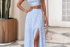 With beige wide brim hat, earrings, white and light blue printed high-waisted midi skirt, beige leather bag and white leather heeled shoes