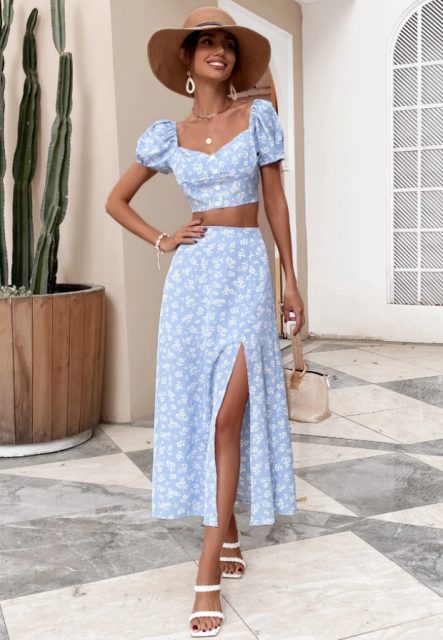 With beige wide brim hat, earrings, white and light blue printed high-waisted midi skirt, beige leather bag and white leather heeled shoes