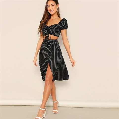 With black and white striped belted wrap knee-length skirt and white ankle strap high heels