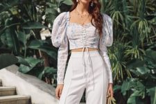 With earrings, white high-waisted palazzo pants and fishnet bag