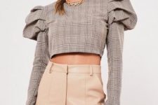 With golden necklace and beige leather high-waisted pants