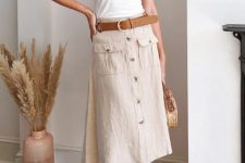 With white fitted top, straw rounded bag and beige leather low heeled sandals
