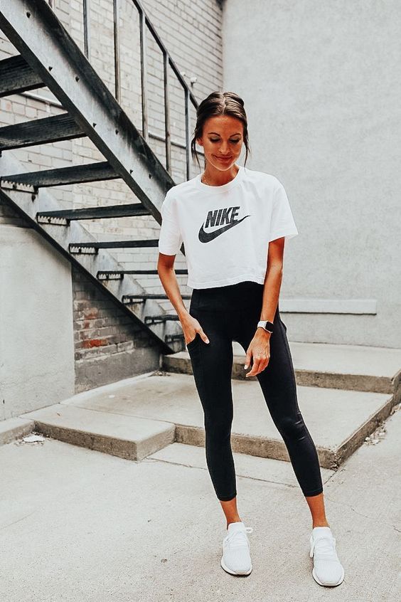 a black and white workout look with black leggings,  a white printed cropped t shirt, white trainers