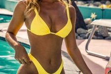 a bold neon yellow bikini with a bra top and a high waisted bottom plus retro-inspired sunglasses for a tropical vacation