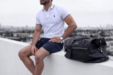 a casual summer look done with classic items – a white polo shirt, navy shorts, white sneakers and a black bag