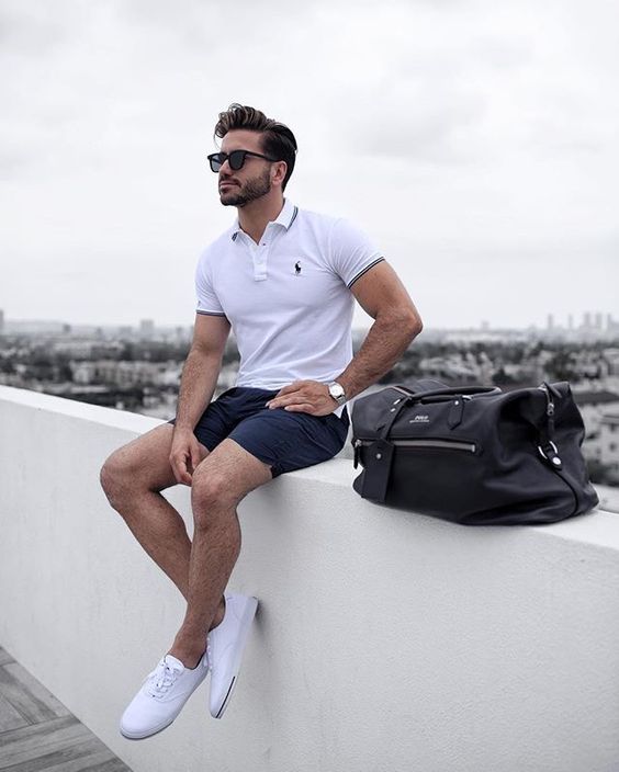 a casual summer look done with classic items   a white polo shirt, navy shorts, white sneakers and a black bag