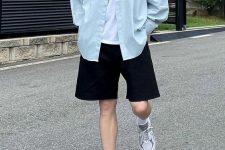 a casual summer outfit with a white tee, a blue oversized shirt, black shorts, white socks and grey trainers