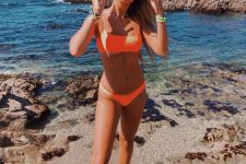a comfy and cool neon orange ribbed bikini with a square neckline bra top and blue sunglasses for a bold look