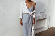 a dusty blue slip midi dress, a knotted white button down, white slippers and a white bag for a relaxed and chic summer look