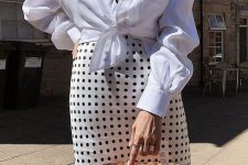 a lovely look with a polka dot printed midi dress, a white knotted shirt, a basket bag and layered necklaces