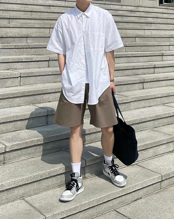 a minimalist summer look with a white tee, a white short sleeve shirt, taupe shorts, grey sneakers and a black bag