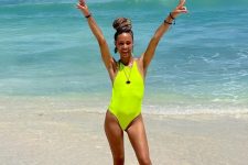 a neon yellow one piece halter neckline swimsuit plus some statement jewelry for an ultimate beach look