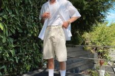 a neutral summer outfit with a white tank top, an oversized white shirt, creamy shorts, white socks and beige chunky shoes