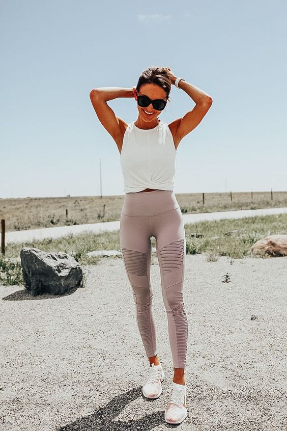 a pastel workout look with a white halter neckline tied up crop top, lilac leggigns and pink trainers is cool for spring and summer