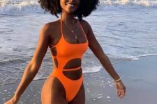 a sexy neon orange one piece swimsuit with multiple cutouts on the front and sides is a perfect idea to go to the beach