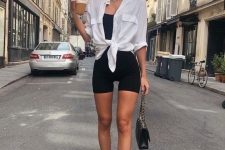 a sport chic summe rlook with a black top, black biker shorts, a white knotted shirt, white socks and trainers and a small black bag
