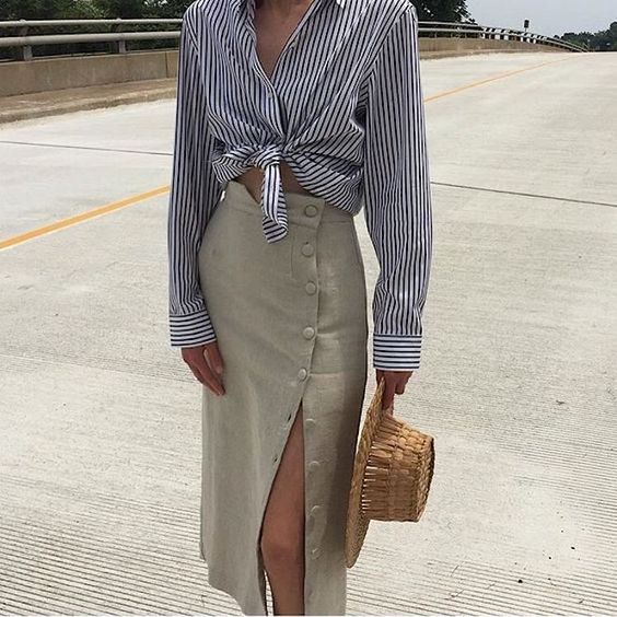 a striped knotted shirt, a neutral linen midi skirt with buttons and a straw hat for a lovely and relaxed summer look