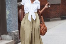 a white knotted linen shirt, yellow linen midi A-line skirt, brown lace up shoes and a brown bag