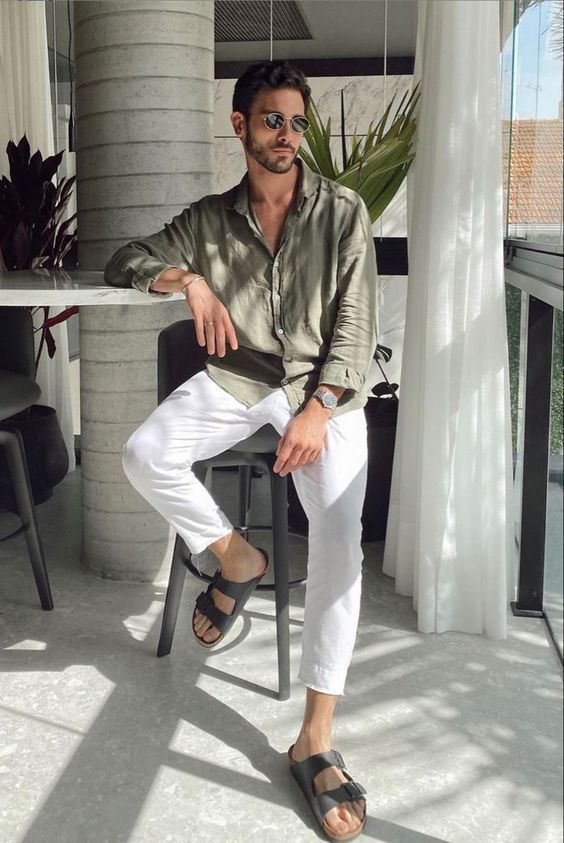 an olive green linen button down, white pants, grey birkenstock sandals and sunglasses are a great combo