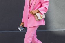 03 a bold pink pantsuit with an oversized blazer, neutral sneakers and a neutral bag are a lovely summer work look