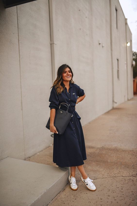 a black midi A-line shirtdress with pockets and a sash, white sneakers and a black tote are a perfect ensemble for work