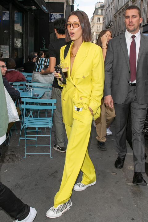 a bold yellow power suit with an oversized blazer, grey sneakers and statement necklaces for work