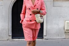 06 a coral pink linen suit with a blazer and Bermuda shorts, a woven bag, white slides and white frame sunglasses