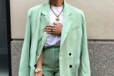 09 a light green suit with a blazer and Bermuda shorts, a white t-shirt, a statement necklace and a small white bag