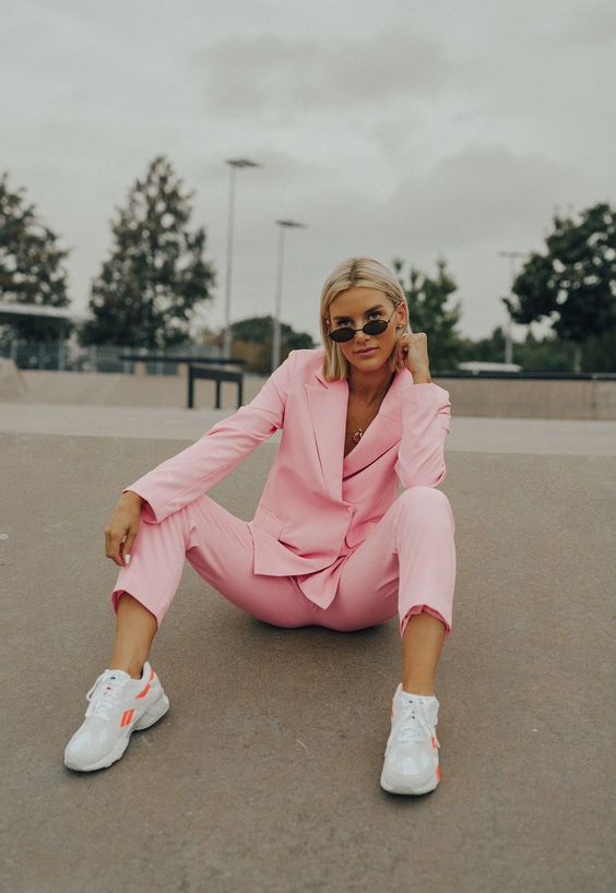 a light pink pantsuit with cropped pants and white trainers are a flawless look for work in summer